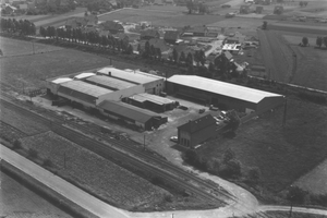  Die ursprüngliche Unternehmenszentrale: das Werk in Isselburg-Werth im Jahr 1963. Heute arbeiten hier rund 400 Mitarbeiter in Produktion und Verwaltung. Auf einer Hallenfläche von 45.000 m² werden in der hochautomatisierten Fertigung Schwingtore und Stahlzargen hergestellt.  